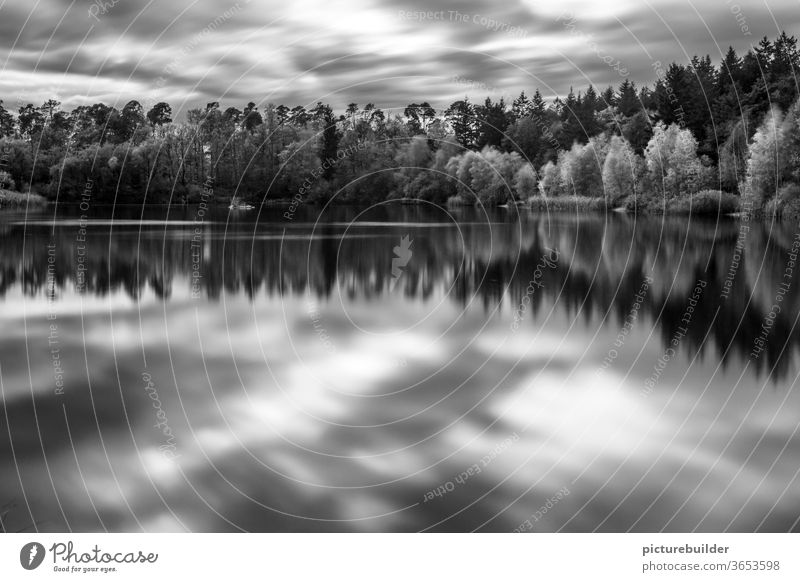 Waldsee Long time exposure Lake Forest Clouds Light reflection Long exposure Landscape Nature bank Autumn foliage Water Black & white photo Day Horizon