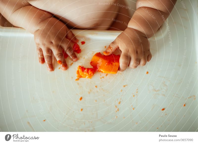 Close up baby eating fruit hands Hand body part Baby babyhood Eating Fruit Papaya Healthy Eating Interior shot Colour photo Nutrition Red Fresh Close-up Sweet