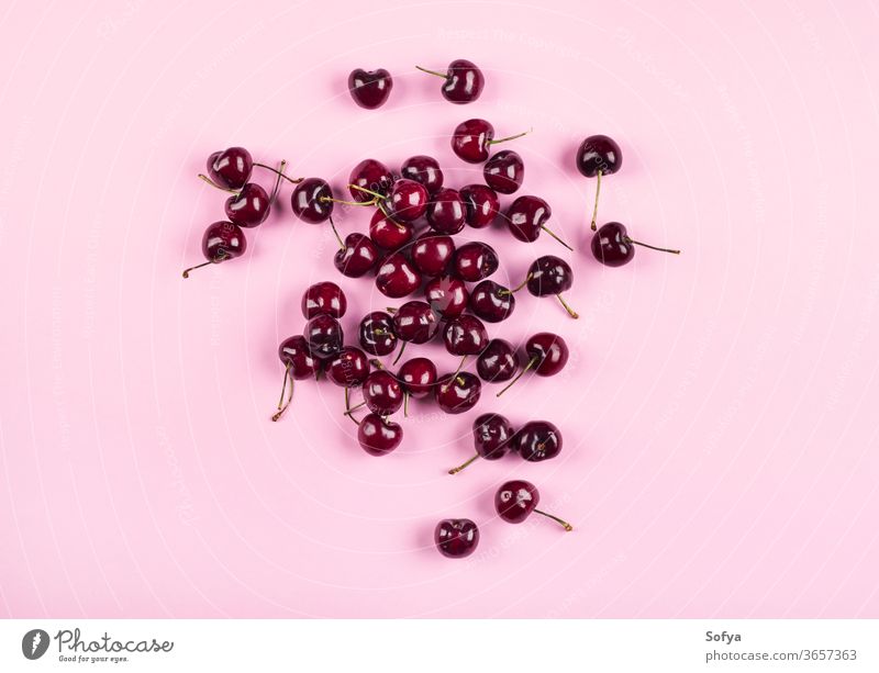 Heap of cherries on pink background. Flat lay cherry produce harvest fashion design food summer pattern flat lay fruit nature texture spring hello sweet tasty