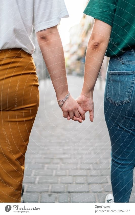 Unrecognizable lesbian couple holding hands unrecognizable love female women homosexual together adult lifestyle people young relationship happy two