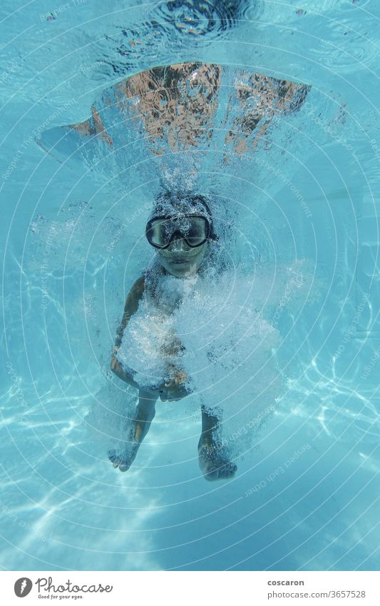 Little girl jumping into a pool and diving action activity aqua park aquatic blue bubbles child clear concept copy space deep down face fitness foam fun glasses