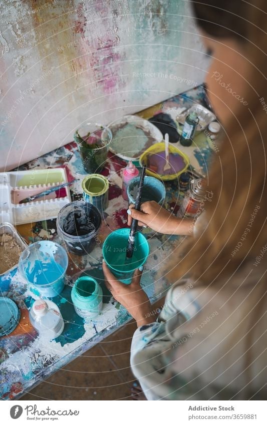 Female artisan working with paints in workshop artist woman color palette creative tool talent prepare craft paintbrush colorful young female draw lifestyle