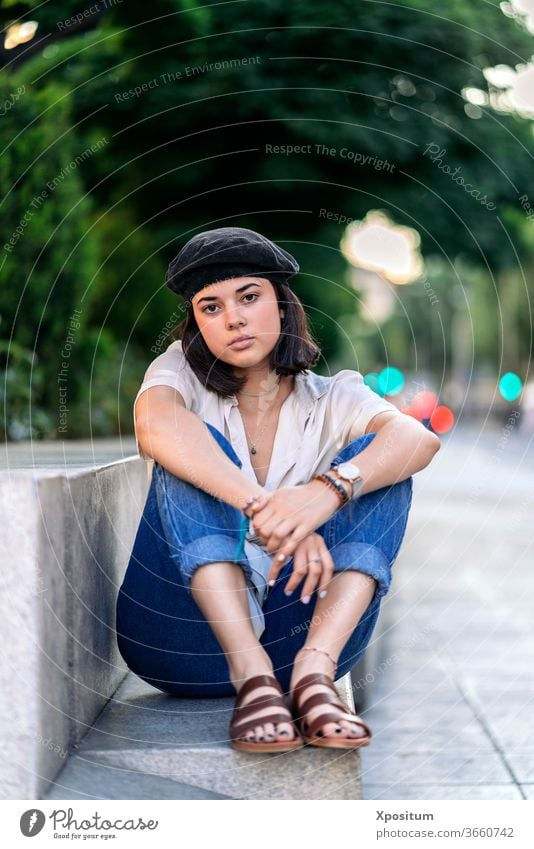 Young woman seating and looking at camera street female portrait city caucasian beautiful young people person fashion girl attractive outdoor beauty urban