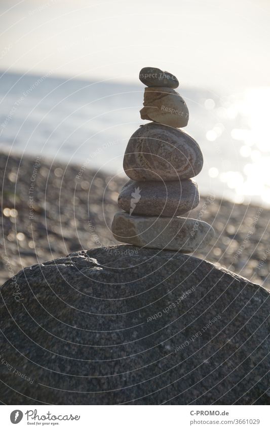 Stack of stones against the light Beach balance harmony Yoga Ocean Sky Sunlight stone stack