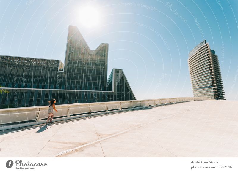 Girl skating on rollerblades against modern futuristic buildings girl ride facade architecture exterior zaragoza skyscraper geometry design abstract symmetry