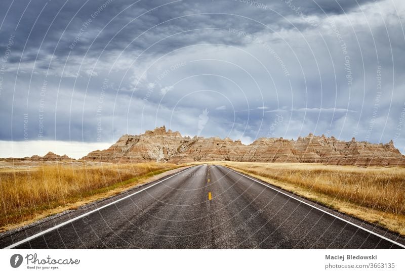Stormy clouds over road in Badlands National Park, USA. travel trip highway journey panorama nature South Dakota landscape freedom scenery adventure horizon