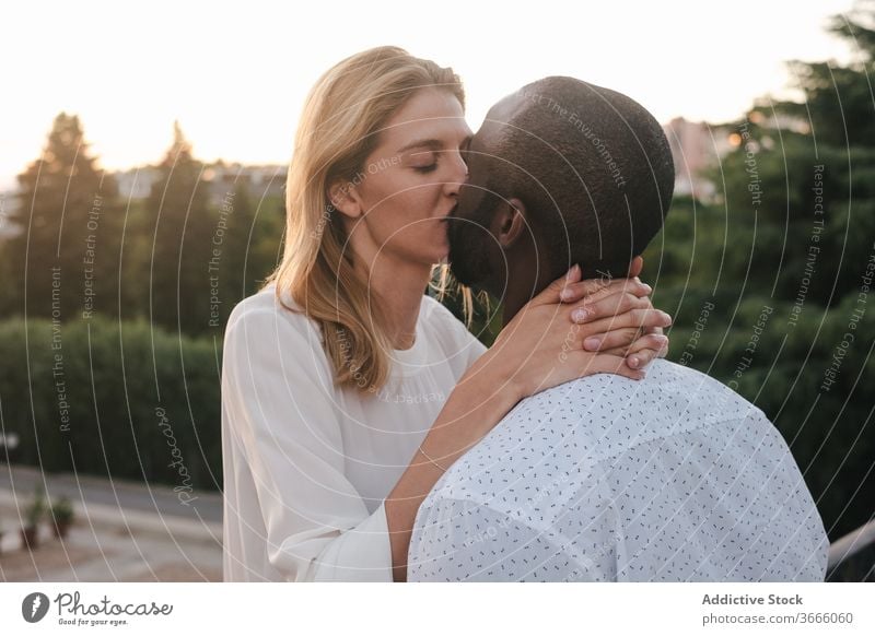 Happy diverse couple kissing on street bonding romantic positive relationship love happy affection embrace modern casual urban city lifestyle multiethnic