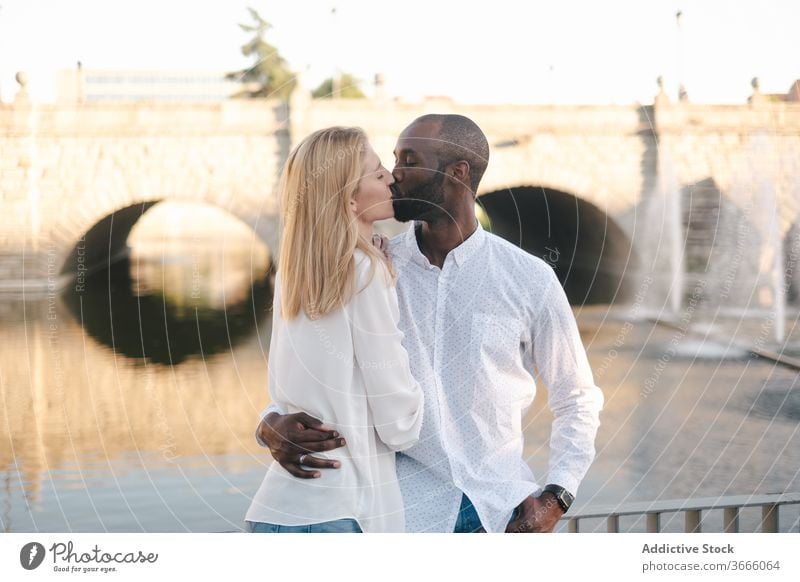 Content multiethnic couple hugging and bonding on street kiss embrace caress cuddle relationship romance love tender content affection modern casual positive