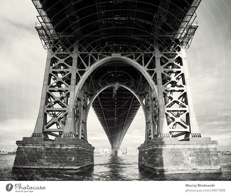 Under the Williamsburg Bridge, New York City, USA. NYC city bridge black and white look up under architecture urban sunset structure view picture river water