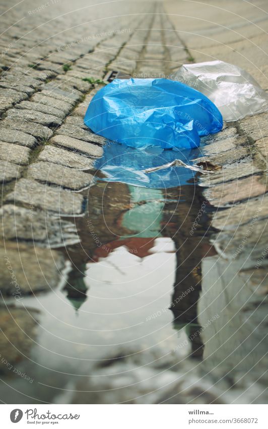 the world sinks into plastic Plastic bag plastic waste Puddle Environmental pollution City hall reflection Paving stone plastic bag Plastic product Marketplace