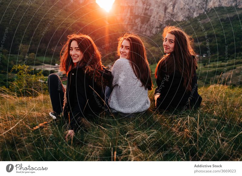Young smiling women on lawn in highlands friend mountain sunset chill together unity friendship girlfriend transylvania romania saint george picturesque grass