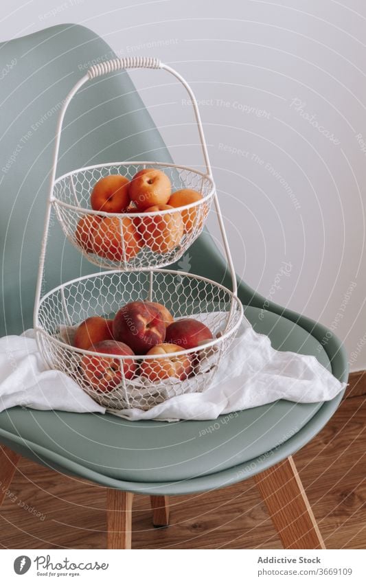 Ripe fruits in metal basket on chair fresh ripe vitamin apricot peach organic natural healthy food nutrition raw delicious tasty sweet summer season meal