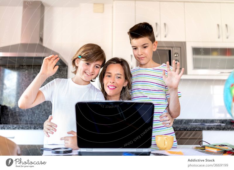 Mother with sons saying hello during video call on laptop mother greeting embrace communicate childhood using device gadget watching netbook internet online