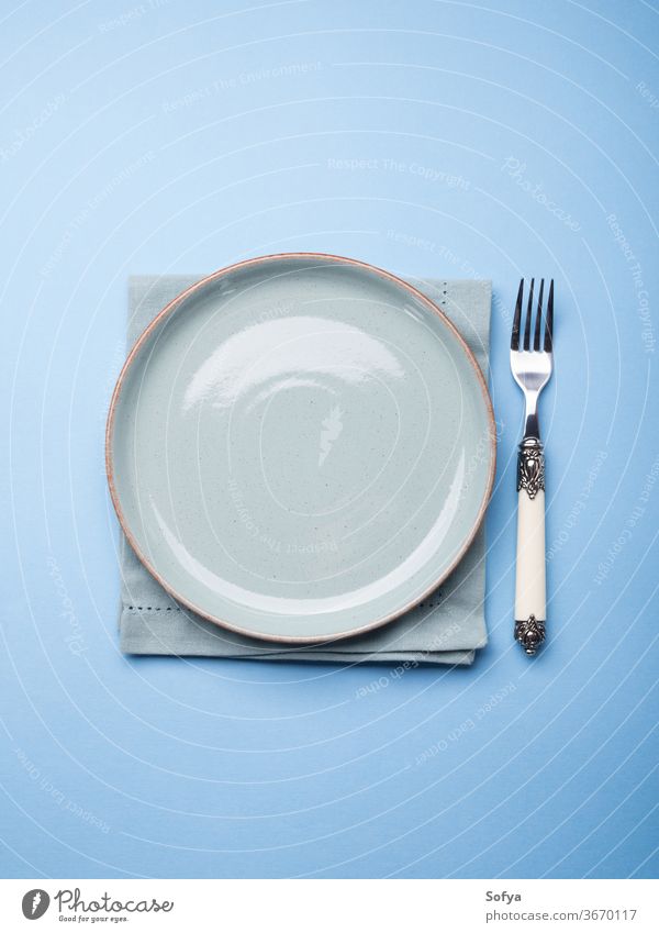Blue pastel ceramic dish on napkin with fork plate empty abstract concept food eat serve setting table blue tableware crockery design dishware monochrome color