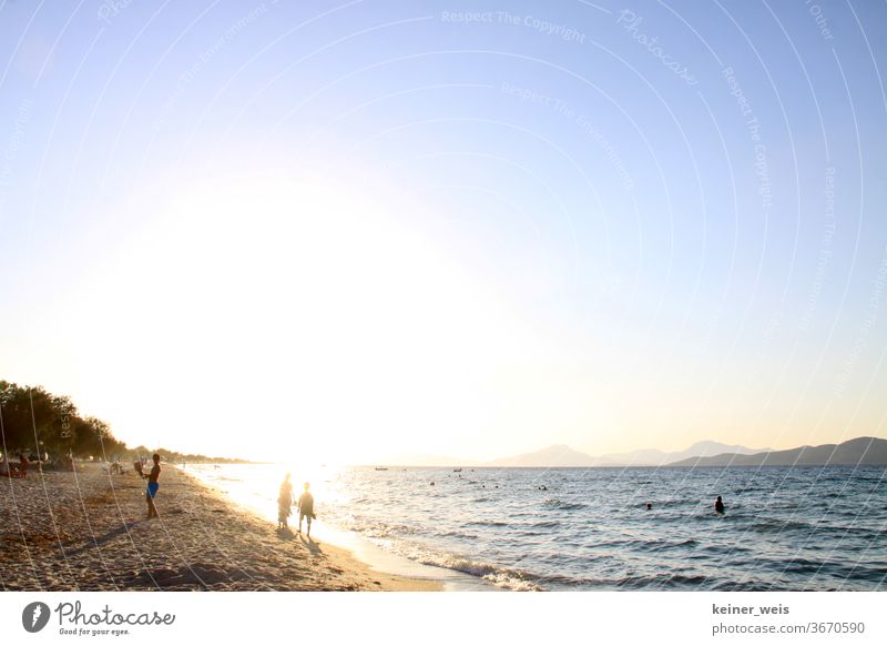 Beach of the Aegean Sea with few people against the light Summer Sun Sunlight Sunset Deep depth of field ägais Greece Blinding lens flair Lensflare Blue sky