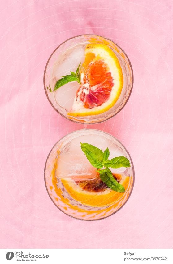 Summer iced citrus drink with mint on pink napkin water cocktail lemonade infused detox blood orange lime fruit summer juice mocktail soda sweet home made slice