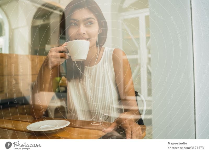Young woman drinking a cup of coffee at coffee shop. young portrait latin outdoors cafe brunette time off confident leisure free time lifestyle refreshment