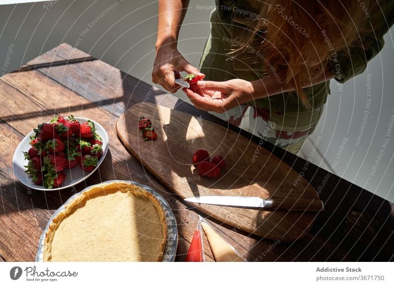 Crop housewife preparing delicious pie at home cook homemade cake woman kitchen dessert peel strawberry prepare female product process fresh recipe pastry table