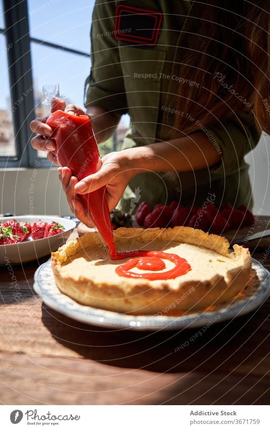 Crop woman decorating cake with cream piping bag squeeze pie cook decorate confectionery homemade female delicious table housewife food yummy palatable sweet