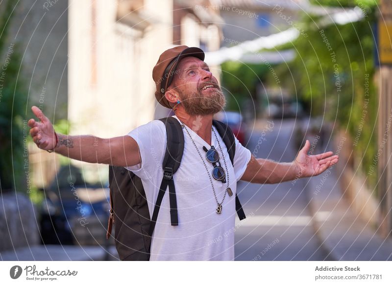 Happy hipster tourist enjoying summer holidays in town traveler man street happy freedom vacation visit sightseeing trendy style male beard journey carefree