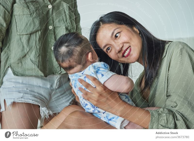 Mother holding her soon and smiling at home family baby child boy dad mom mother fun enjoy stay at home beautiful model portrait flat people happy family