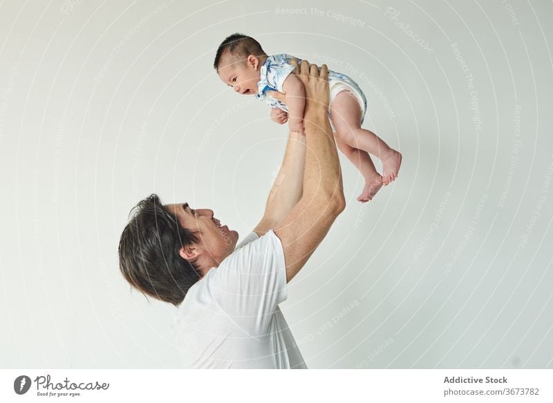 Father lifting up his baby family child soon boy dad father fun enjoy home at home stay at home beautiful model portrait flat people happy family caucasian