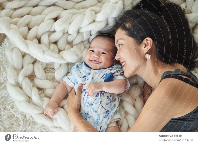 Mother lying with her son in bed family baby child boy fun enjoy home at home stay at home beautiful model portrait flat people happy family caucasian chinese
