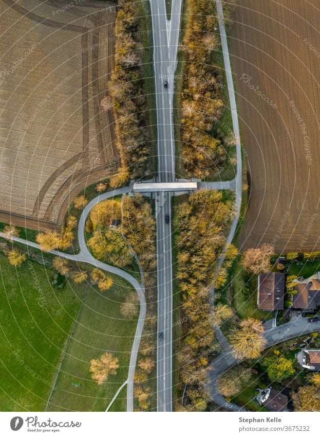 Top view from a drone at a street with cars and a bridge. autumn fall foliage nature colorful road landscape scenic europe natural vibrant rural season