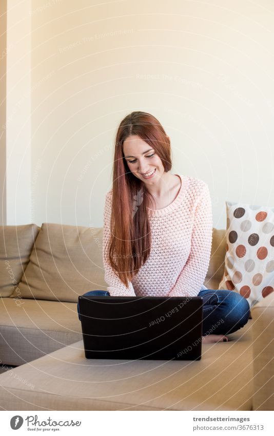 Woman on couch with laptop woman home sofa young using happy technology room sitting beautiful digital casual female indoors person modern internet pretty