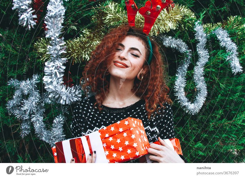 Young happy redhead woman near a christmas tree on holidays gift people real pretty young youth happiness merry christmas decor decoration hairband horns