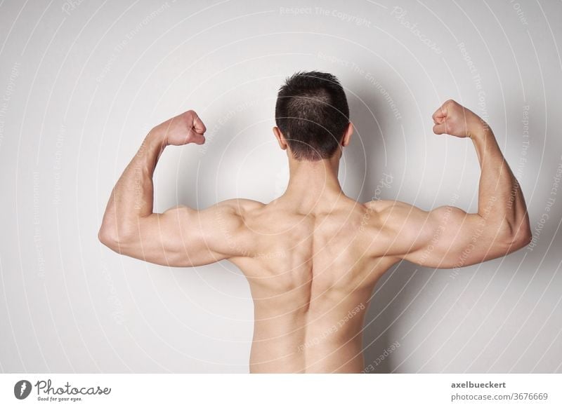 man flexing biceps and back muscles bodybuilder strength power strong arm bodybuilding male muscular fit fitness athletic athlete sports shirtless masculine