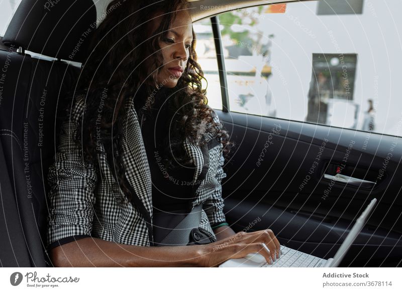 Businesswoman using laptop in car businesswoman work busy modern serious gadget young african american black ethnic trip urban device female entrepreneur