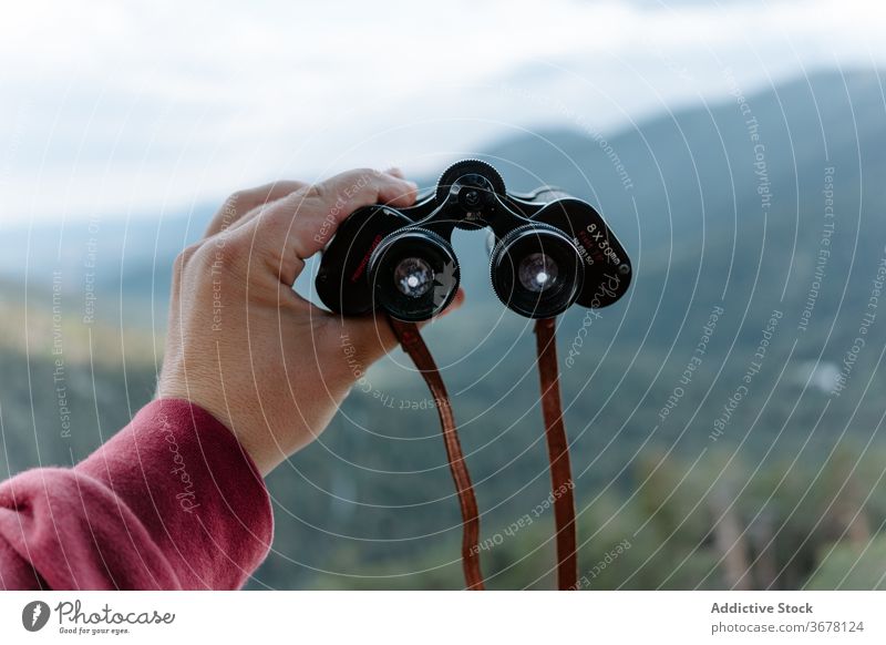 Traveler exploring nature with binoculars mountain explore hike travel activity discovery observe adventure location forest trekking hand lens optical
