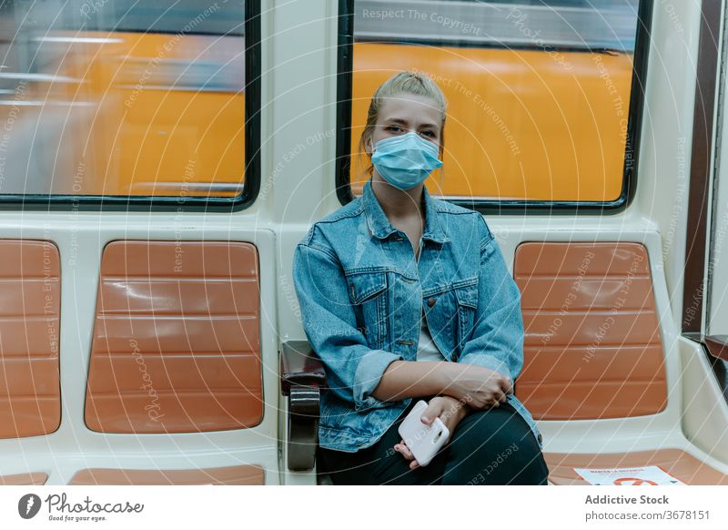 Young woman in protective mask in subway train coronavirus passenger metro social distancing covid pandemic restriction infection female seat alone underground