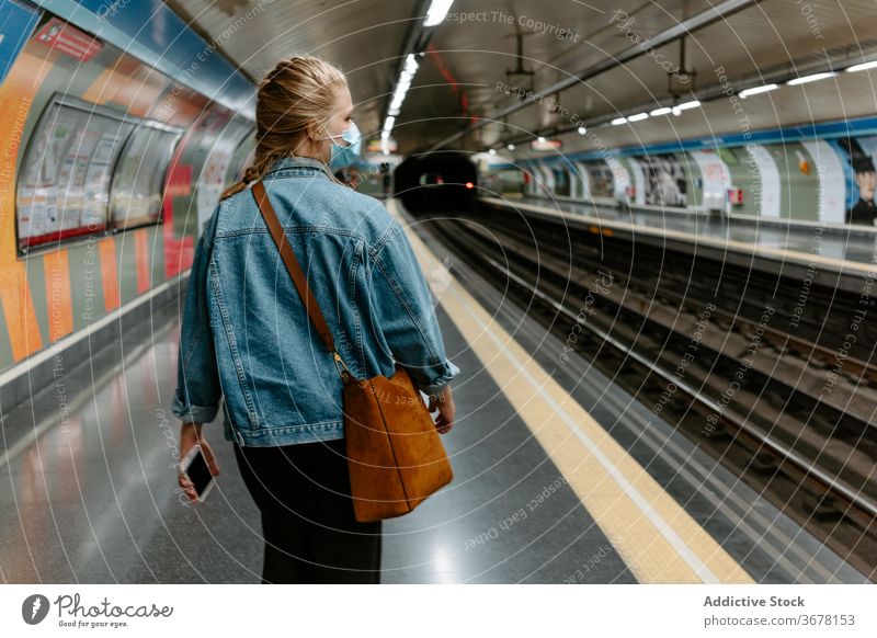 Modern woman in protective mask walking on subway platform metro coronavirus passenger covid pandemic infection female casual young underground station railway