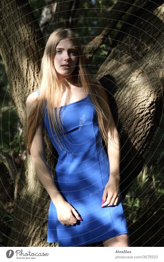 Blond preteen girl in blue dress close up summer photo on
