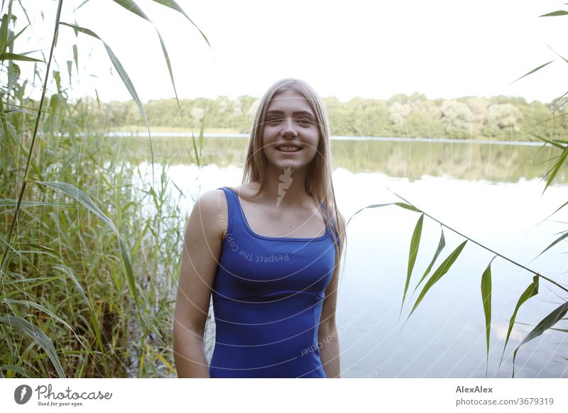 Portrait of a young woman in a blue summer dress in a lake on the shore Purity luck Beautiful weather Trip Expectation Sunlight Close-up Day