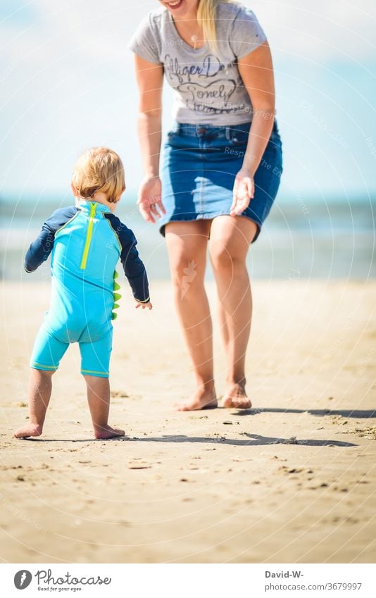 little boy runs insecurely the first steps on the beach into the arms of his mother Walking Going walking attempts Steps Child Toddler Sweet Cute Beach vacation
