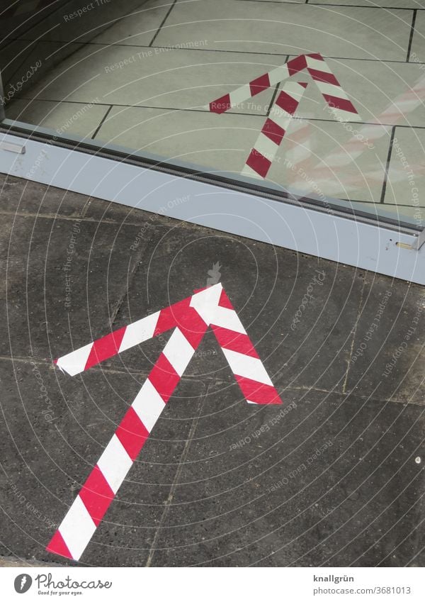 Red and white arrows glued to the floor as signposts Road marking Arrow Striped Signs and labeling Direction Orientation Navigation Clue Lanes & trails Signage