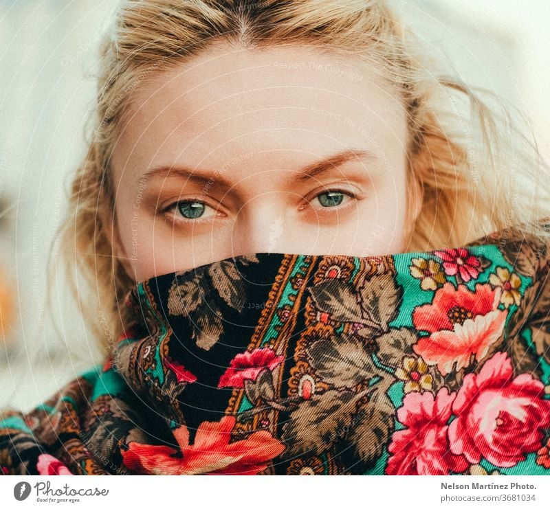 Portrait of a causasian blonde.  She is looking directly at the camera covered in a floral patterned scarf. portrait caucasian Woman Portrait photograph