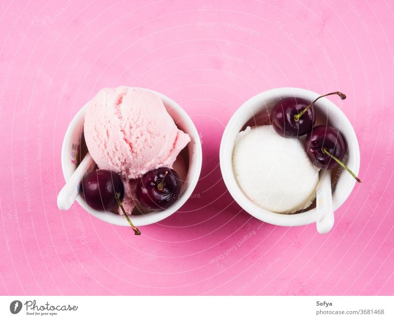 Two ice cream cups with cherries on pink strawberry scoop ball gelato red cherry berries yogurt summer sundae sweet fruit temptation topping food frozen garnish