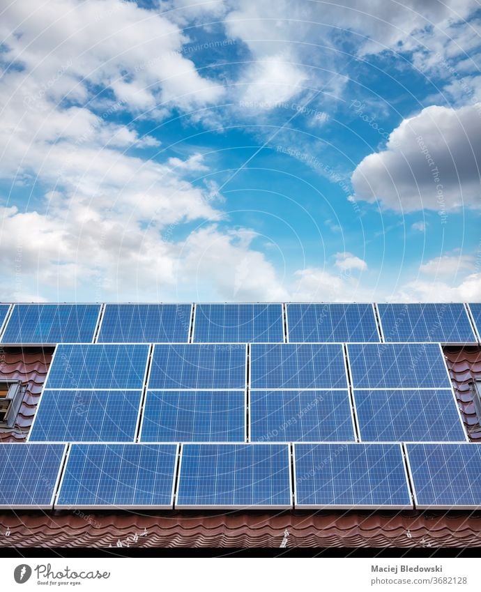 Solar photovoltaic panels on a roof of a house. solar power green home building energy technology sky electricity clean renewable blue ecology innovation