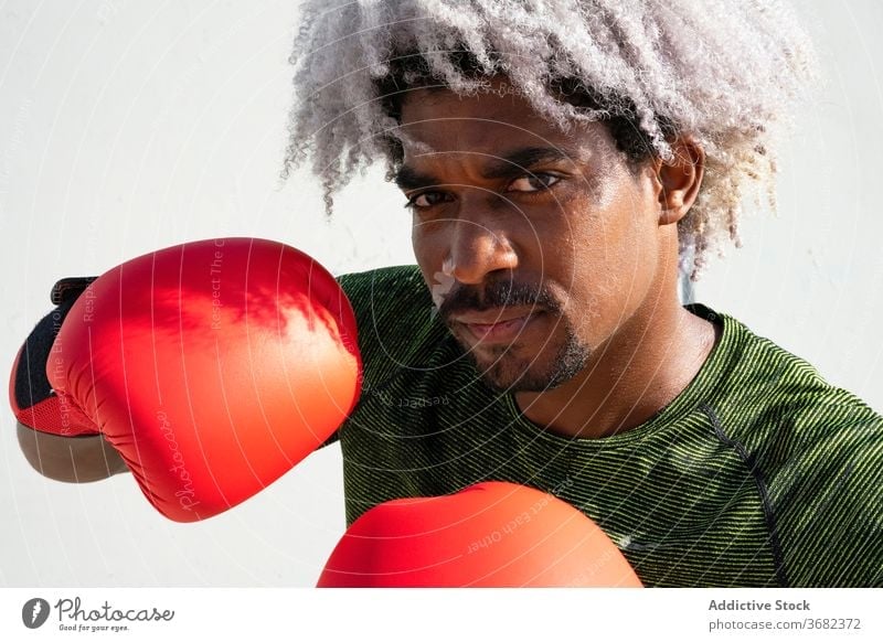 African American boxer ready for training sportsman stance guard serious street wall shabby male workout boxing power black ethnic african american athlete