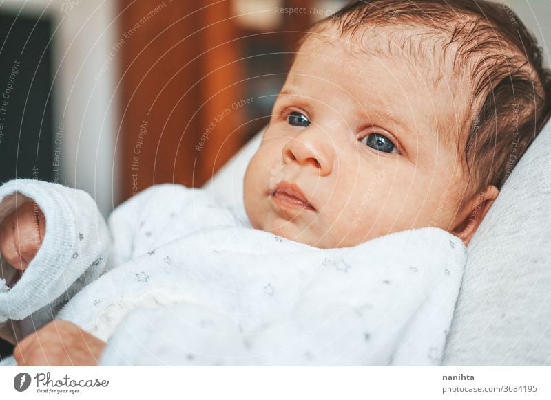 Lovely newborn baby girl with a warm pajama at home cute adorable funny boy kid daughter son face expressive expression growth upbringing nurture skin issues
