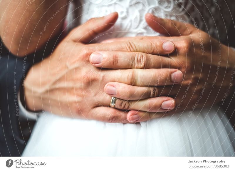 Close up of groom's palms embracing bride. ring wedding embrace close up waist hug detail fingers concept hand newlywed emotions caucasian lifestyles marriage