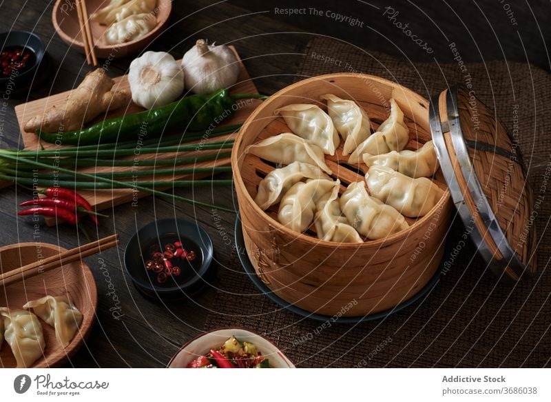 Chinese steamed dumplings xiaolongbao jiaozi chinese food yummy wood dark food vegetables salad cucumber foodie tradition traditional Asia Asian food chopsticks