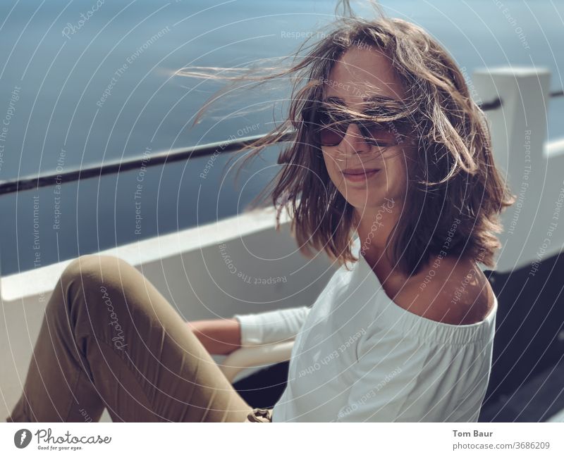 Portrait of a brunette woman with flowing hair and sunglasses Woman portrait blowing hair Sunglasses Looking into the camera Easygoing Exterior shot already