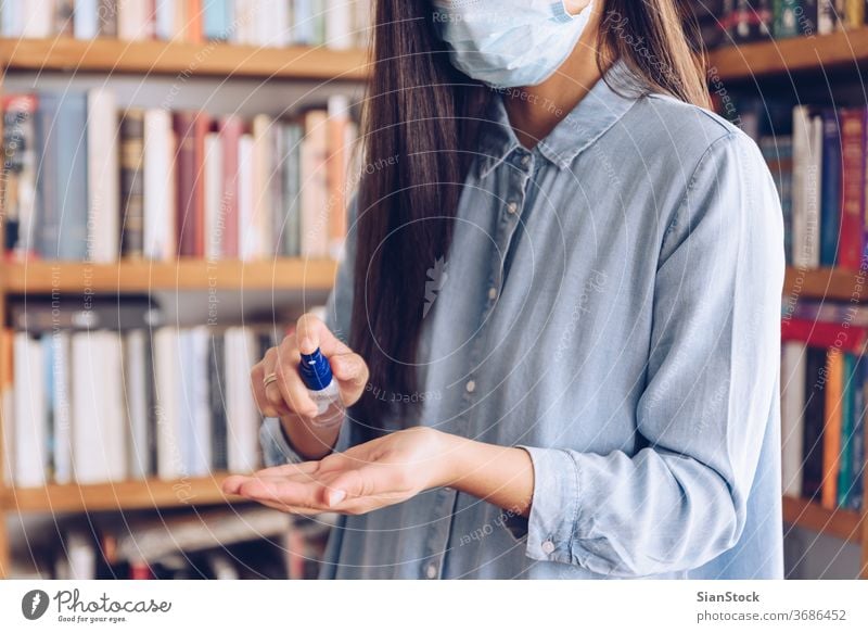 Coronavirus concept. Girl in her home spray with antiseptic her hands for protection from coronavirus. Global call to stay home. covid quarantine gloves