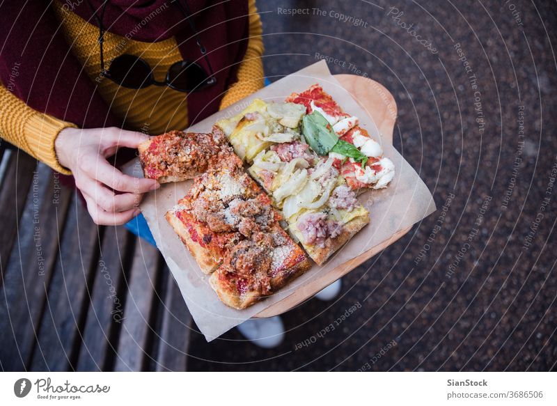 Top view of woman hand taking pizza food italian italy cheese tomato street mozzarella meal closeup hands hold holdind top young slices traditional ham cuisine