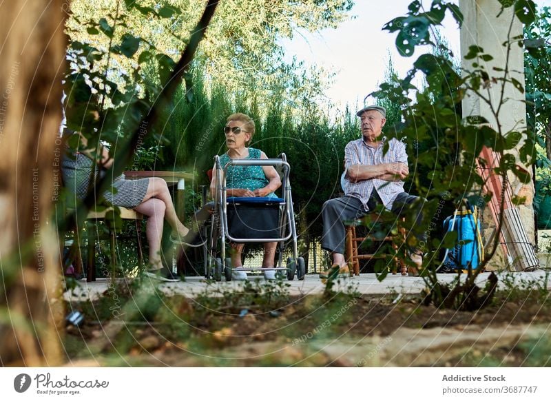 Group of senior people sitting on terrace of house elderly grandparent gather yard together old mask coronavirus protect covid pandemic lifestyle aged